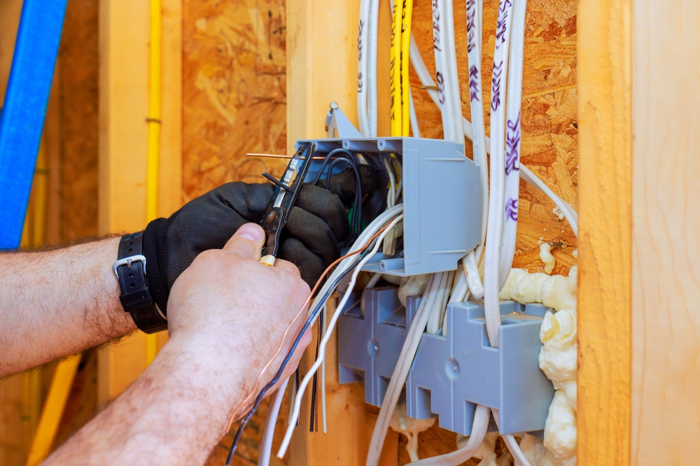 Licensed electrician wiring a new construction home